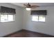 Bright bedroom with wood floors, ceiling fan, and two windows providing ample natural light at 9880 Sw 101St Pl, Ocala, FL 34481