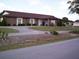 Brick clubhouse with a well-manicured lawn and winding driveway, providing an inviting community space at 9880 Sw 101St Pl, Ocala, FL 34481