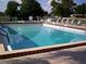 Sparkling community swimming pool surrounded by lounge chairs and secure fencing at 9880 Sw 101St Pl, Ocala, FL 34481