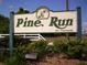 Entrance sign for Pine Run, a 55+ community, with lush landscaping and a welcoming atmosphere at 9880 Sw 101St Pl, Ocala, FL 34481