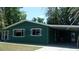 Charming single-story green home with a covered carport and well-maintained front lawn at 9880 Sw 101St Pl, Ocala, FL 34481