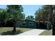 Green home featuring palm trees, carport and a sunroom at 9880 Sw 101St Pl, Ocala, FL 34481