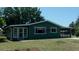 Cozy green home featuring a carport, sunroom and manicured landscaping at 9880 Sw 101St Pl, Ocala, FL 34481