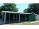 View of the back exterior of the home with a patio with multiple windows at 9880 Sw 101St Pl, Ocala, FL 34481