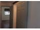 Hallway with a slider door reveals a bedroom with hardwood floors and a window with drapes at 9880 Sw 101St Pl, Ocala, FL 34481