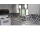 Updated kitchen with gray cabinets, mosaic tile backsplash, and stainless steel appliances at 9880 Sw 101St Pl, Ocala, FL 34481