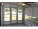 Enclosed patio featuring windows, ceiling fan and door to exterior at 9880 Sw 101St Pl, Ocala, FL 34481