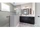 This bathroom offers a glass enclosed shower with black fixtures, gray tile, and a vanity with marble countertop at 10082 Sw 82Nd Place Rd, Ocala, FL 34481