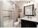 Clean bathroom includes a shower/bathtub combo, a black vanity with marble countertop, and decorative accents at 10082 Sw 82Nd Place Rd, Ocala, FL 34481