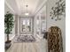 Elegant foyer with decorative rug, high ceilings, a large plant, and glass paneled entry doors at 10082 Sw 82Nd Place Rd, Ocala, FL 34481