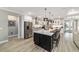 Open kitchen with stainless steel appliances, a large island, and modern light fixtures at 10082 Sw 82Nd Place Rd, Ocala, FL 34481