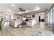 Open concept living room featuring wood-look flooring, tray ceiling, and stylish decor at 10082 Sw 82Nd Place Rd, Ocala, FL 34481