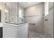 Close up on shower with gray tiled walls, built-in shelf and seat, and glass surround at 10082 Sw 82Nd Place Rd, Ocala, FL 34481