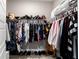 Walk-in closet with multiple rows of hanging clothes and several pairs of shoes at 10082 Sw 82Nd Place Rd, Ocala, FL 34481