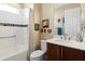 Bright bathroom featuring a shower-tub combo and a dark wood vanity with ample countertop space at 10327 Sw 96Th Loop, Ocala, FL 34481
