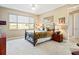 Bright bedroom with large window, ceiling fan, patterned bedspread and carpeted flooring at 10327 Sw 96Th Loop, Ocala, FL 34481