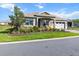 Attractive home showcasing a well-manicured lawn, lush landscaping, and a paved driveway at 10327 Sw 96Th Loop, Ocala, FL 34481