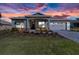 Beautiful home featuring manicured lawn and flowering landscape beneath a dramatic sunset sky at 10327 Sw 96Th Loop, Ocala, FL 34481