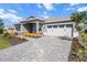 Inviting single-story home with a neat yard, a stone driveway, and a two-car garage at 10327 Sw 96Th Loop, Ocala, FL 34481