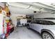 Cluttered two car garage featuring lots of storage and a silver Subaru Outback at 10327 Sw 96Th Loop, Ocala, FL 34481