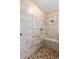 Tiled walk-in shower with pebble floor, built-in bench and showerhead at 10327 Sw 96Th Loop, Ocala, FL 34481