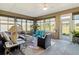Inviting sunroom with ample natural light, comfortable seating, and views of the landscaped surroundings at 10327 Sw 96Th Loop, Ocala, FL 34481