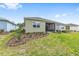 Backyard featuring a grassy lawn, landscaped beds, and a covered screened lanai at 10347 Sw 99Th Ln, Ocala, FL 34481