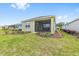 Landscaped backyard with grass, flowerbeds and a view of screened in porch at 10347 Sw 99Th Ln, Ocala, FL 34481