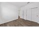 An empty bedroom with wood-look floors, a double door closet and white base molding at 10347 Sw 99Th Ln, Ocala, FL 34481