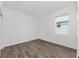 A bedroom with wood-look floors, white walls, a window with blinds and base molding at 10347 Sw 99Th Ln, Ocala, FL 34481