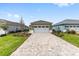 Charming single-story home featuring a paved driveway and a 2-car garage with a lush green lawn at 10347 Sw 99Th Ln, Ocala, FL 34481