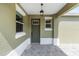 Inviting covered front porch with lantern lighting and neutral color palette, perfect for relaxing outdoors at 10347 Sw 99Th Ln, Ocala, FL 34481