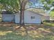 Back exterior of light blue home with green lawn and a mature tree providing shade at 11025 Sw 64Th Ave, Ocala, FL 34476