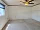 Spacious bedroom featuring neutral carpet, floral wallpaper border, and a ceiling fan with light fixture at 11025 Sw 64Th Ave, Ocala, FL 34476