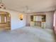 Large neutral carpeted living room open to kitchen with small breakfast bar at 11025 Sw 64Th Ave, Ocala, FL 34476