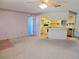 Neutral carpeted living room with a ceiling fan open to the kitchen and a doorway on the left at 11025 Sw 64Th Ave, Ocala, FL 34476