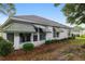 Exterior rear view showing a home's back patio and garden, framed by mature trees at 11146 Sw 68Th Ct, Ocala, FL 34476