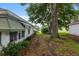 Side view of a home's backyard with mature trees and a glimpse of neighboring houses at 11146 Sw 68Th Ct, Ocala, FL 34476