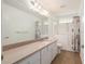 Bright bathroom featuring walk-in tub, decorative shower curtain, granite-topped vanity, and large mirror at 11146 Sw 68Th Ct, Ocala, FL 34476