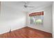 Cozy bedroom with wood floors, a ceiling fan, and a window with red and white striped valance at 11146 Sw 68Th Ct, Ocala, FL 34476