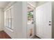 Bright entryway with a white front door, window and light flooring at 11146 Sw 68Th Ct, Ocala, FL 34476