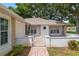 Charming front exterior with brick accents, a white picket fence and manicured landscaping at 11146 Sw 68Th Ct, Ocala, FL 34476