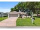 Charming home with brick paved driveway, lush lawn, and manicured landscaping at 11146 Sw 68Th Ct, Ocala, FL 34476
