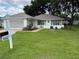 Inviting home with lush lawn, brick pathway, and a 'For Sale' sign for easy contact at 11146 Sw 68Th Ct, Ocala, FL 34476
