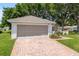 Garage with brick paved driveway and lush lawn at 11146 Sw 68Th Ct, Ocala, FL 34476