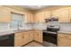 Bright kitchen with light wood cabinets, stainless steel oven, and large sink under a window at 11146 Sw 68Th Ct, Ocala, FL 34476