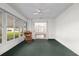 Bright sunroom with multiple windows, a ceiling fan, green carpet, and a cozy chair at 11146 Sw 68Th Ct, Ocala, FL 34476
