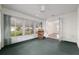 Bright sunroom with lots of natural light, featuring green carpet and inviting furniture at 11146 Sw 68Th Ct, Ocala, FL 34476