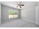 A neutral bedroom with a ceiling fan fixture and natural light from the adjacent window at 12720 Sw 73Rd Street, Ocala, FL 34481