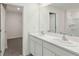 Bright bathroom featuring double sinks, modern fixtures, and an open doorway to the bedroom and walk-in closet at 15095 Sw 35Th Cir, Ocala, FL 34473
